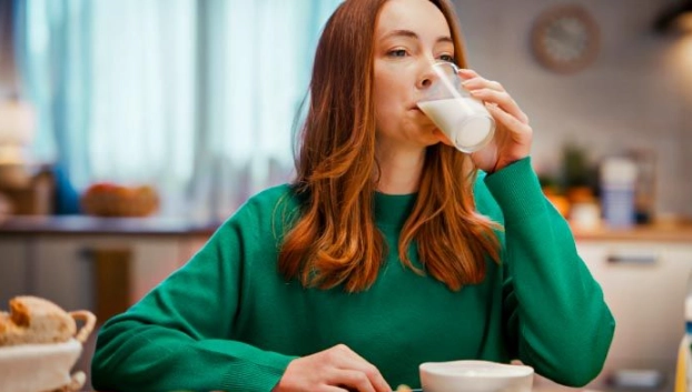 Mujer consumiendo leche de origen español durante el desayuno